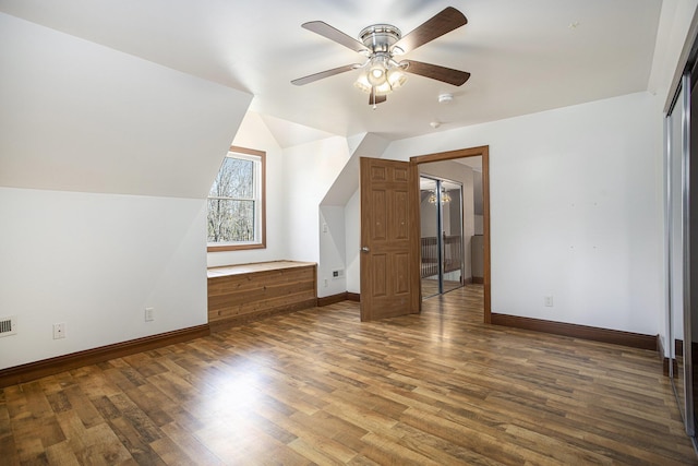 bonus room featuring baseboards, ceiling fan, wood finished floors, and lofted ceiling