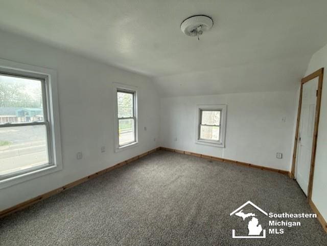 additional living space with baseboards, carpet floors, and vaulted ceiling