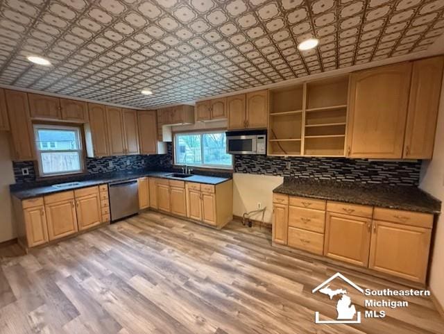 kitchen featuring open shelves, appliances with stainless steel finishes, decorative backsplash, and a sink