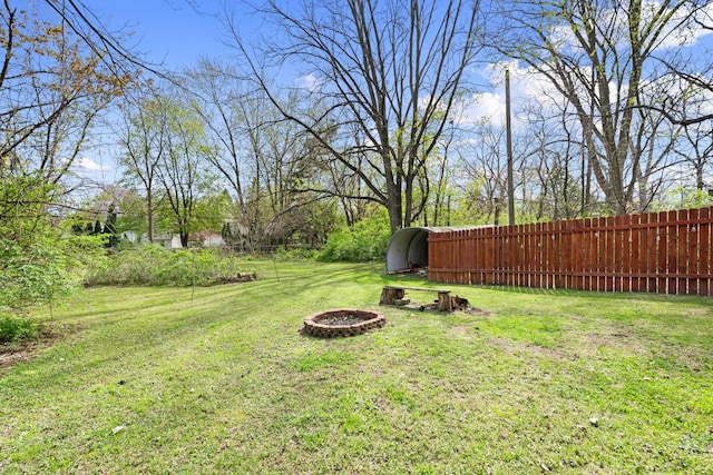 view of yard featuring fence and an outdoor fire pit