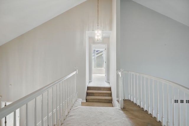 3351 Muerknoll Dr, Troy, MI 48084 - staircase featuring carpet floors, vaulted ceiling, and a chandelier