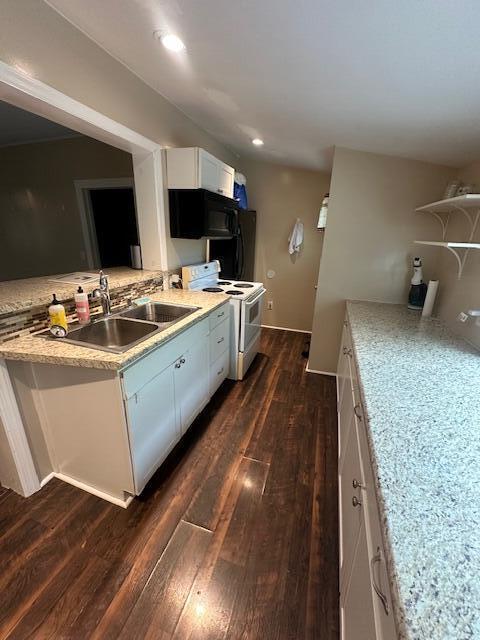 kitchen with black microwave, a sink, light countertops, electric stove, and dark wood-type flooring