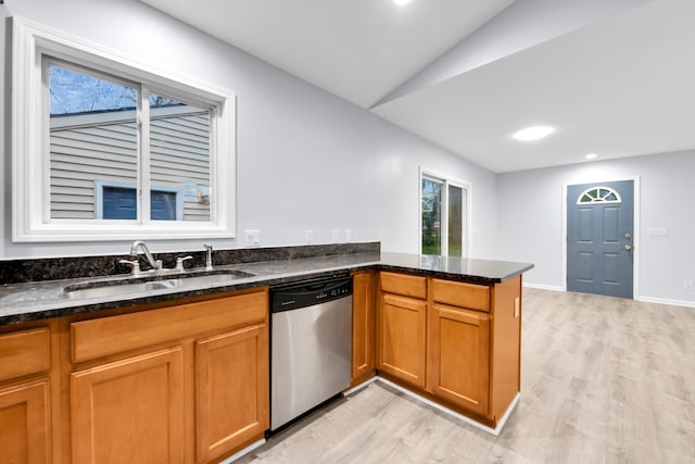 kitchen featuring light wood-style floors, a sink, lofted ceiling, and dishwasher