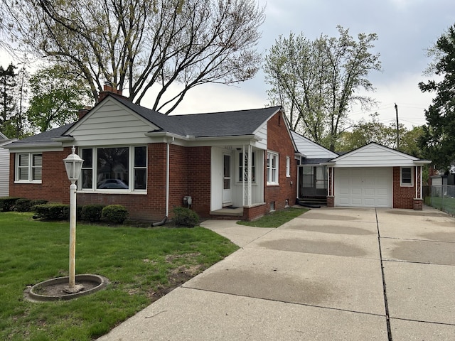 view of front of home featuring brick siding, a chimney, driveway, and a front yard