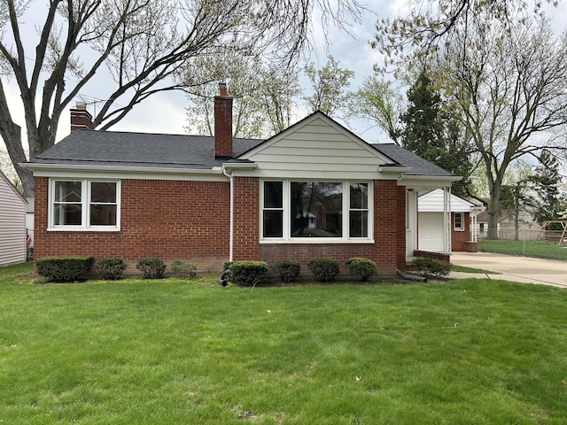 ranch-style home featuring brick siding, a garage, a front yard, a chimney, and driveway