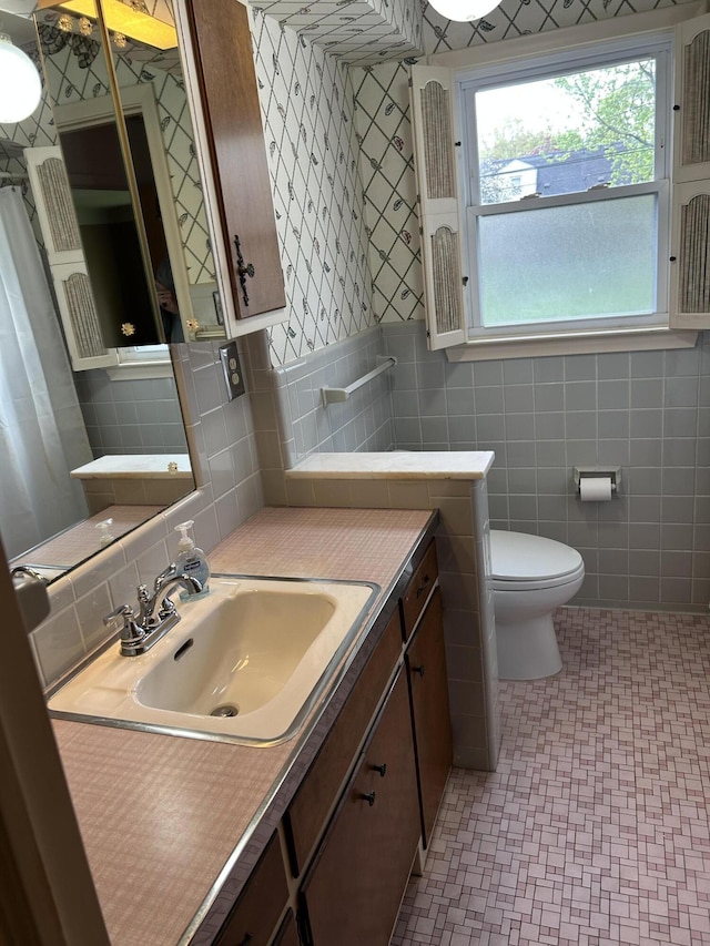 bathroom featuring vanity, tile patterned floors, toilet, and tile walls