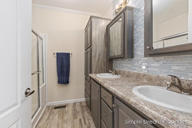 bathroom featuring a sink, baseboards, ornamental molding, and backsplash