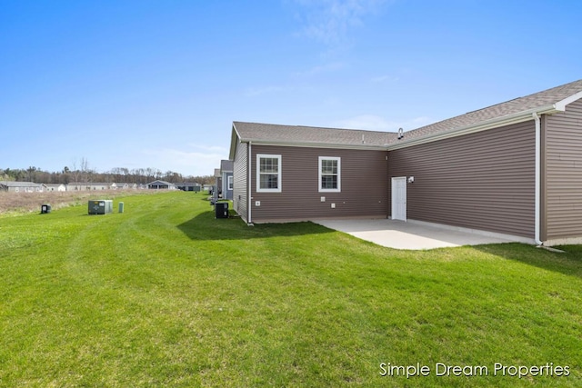 rear view of house with a lawn, cooling unit, and a patio area