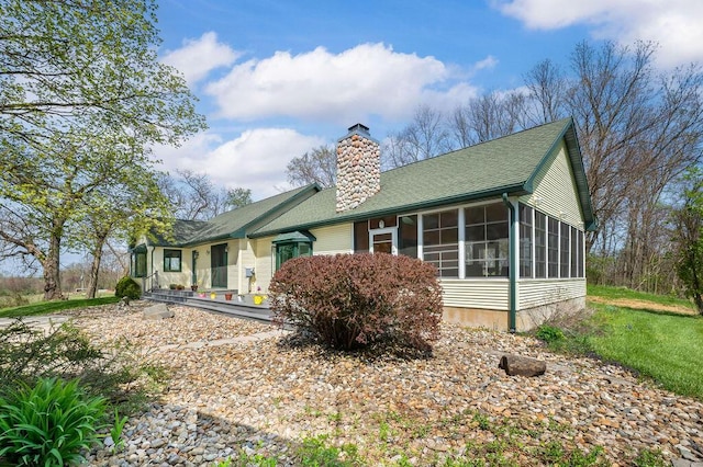 19117 Beaver Dam Rd, Galien, MI 49113 - back of house featuring a sunroom, a shingled roof, and a chimney