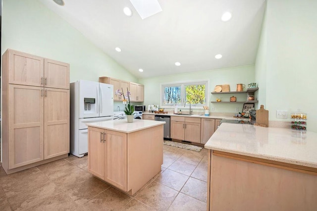 19117 Beaver Dam Rd, Galien, MI 49113 - kitchen featuring light brown cabinets, light stone countertops, vaulted ceiling with skylight, a sink, and stainless steel appliances