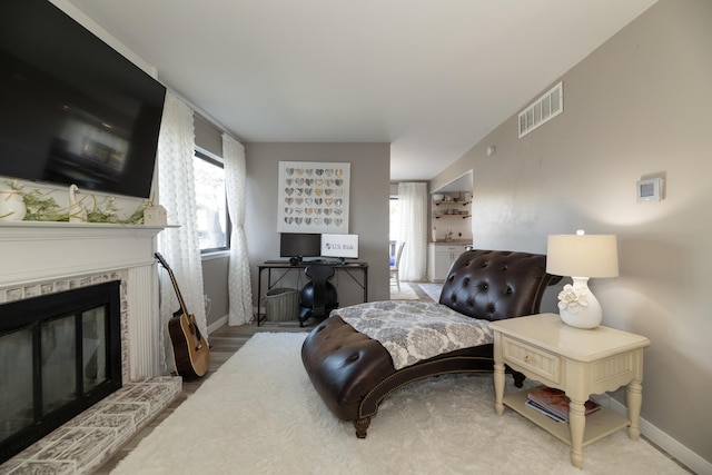 living room with baseboards, visible vents, and a glass covered fireplace