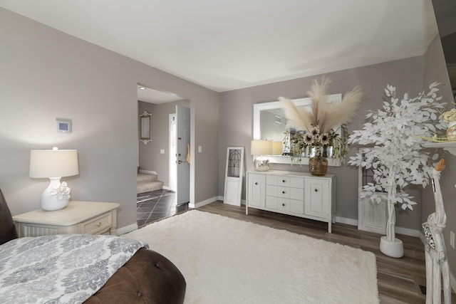 bedroom with baseboards and dark wood-type flooring