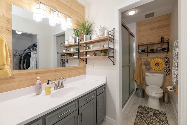 full bath featuring vanity, a shower stall, toilet, and visible vents
