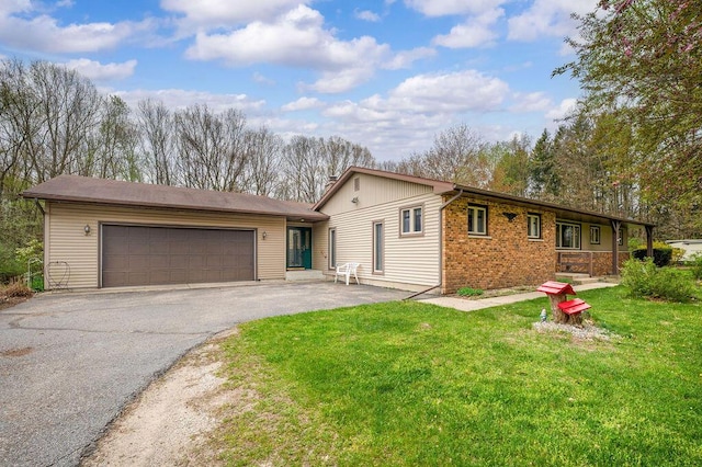 ranch-style home featuring driveway, a front yard, and a garage