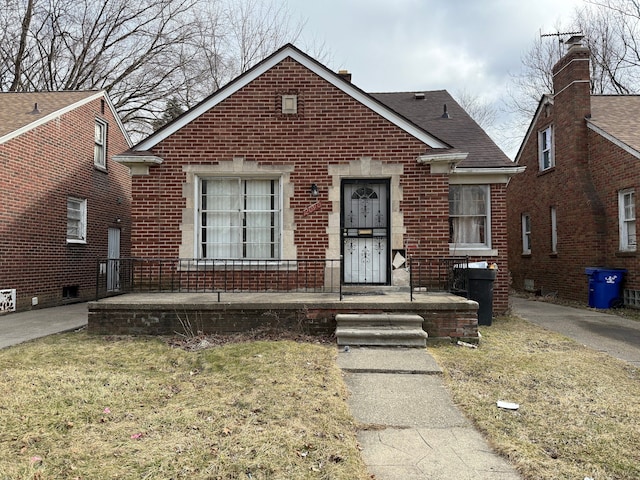 bungalow with covered porch and brick siding