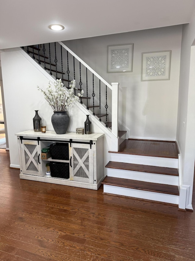 stairway featuring baseboards and hardwood / wood-style flooring