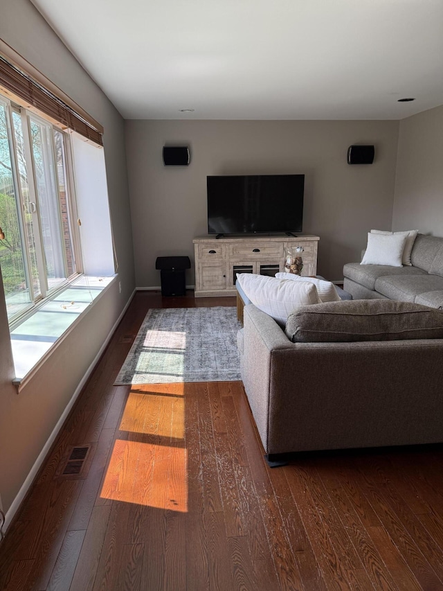 living room featuring baseboards, dark wood-type flooring, and visible vents