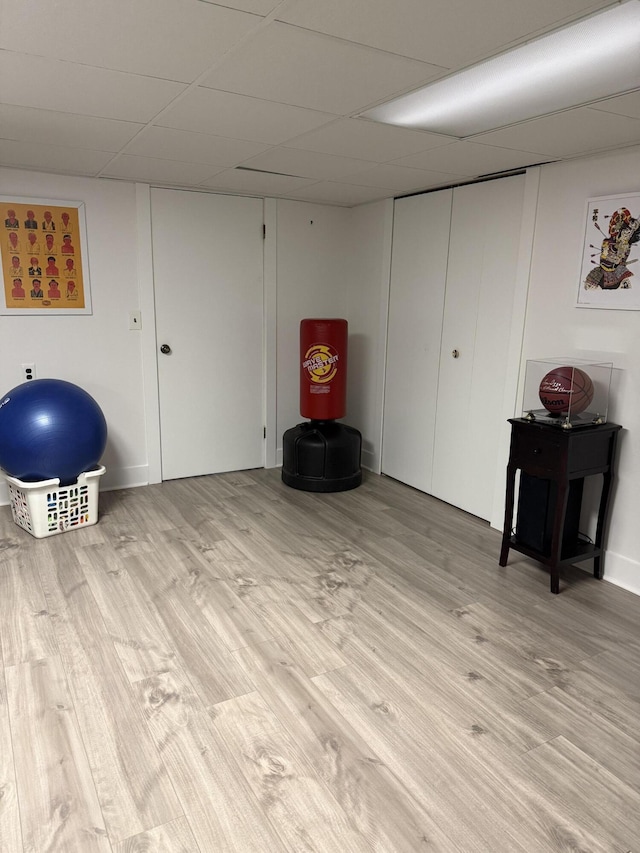 finished below grade area featuring wood finished floors and a drop ceiling