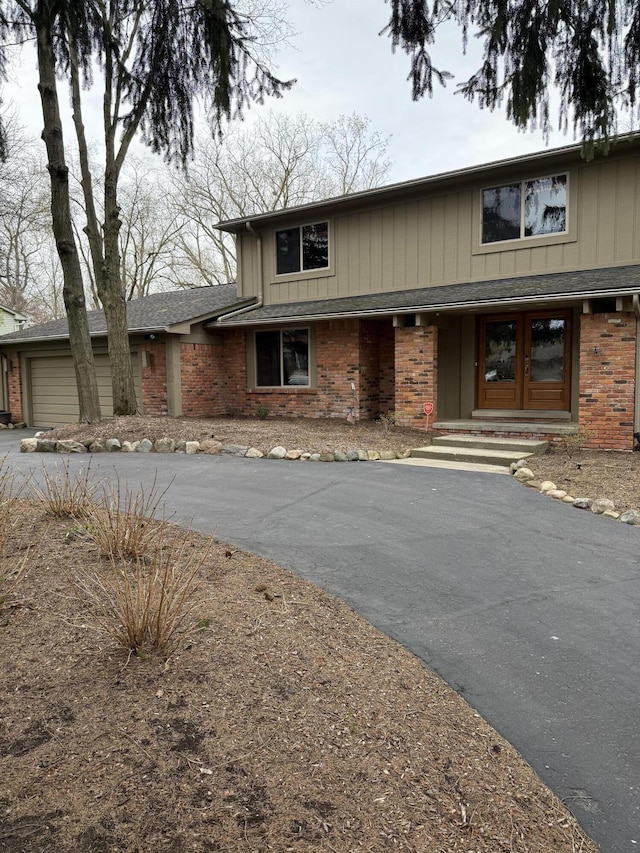 traditional-style home with an attached garage, driveway, and brick siding