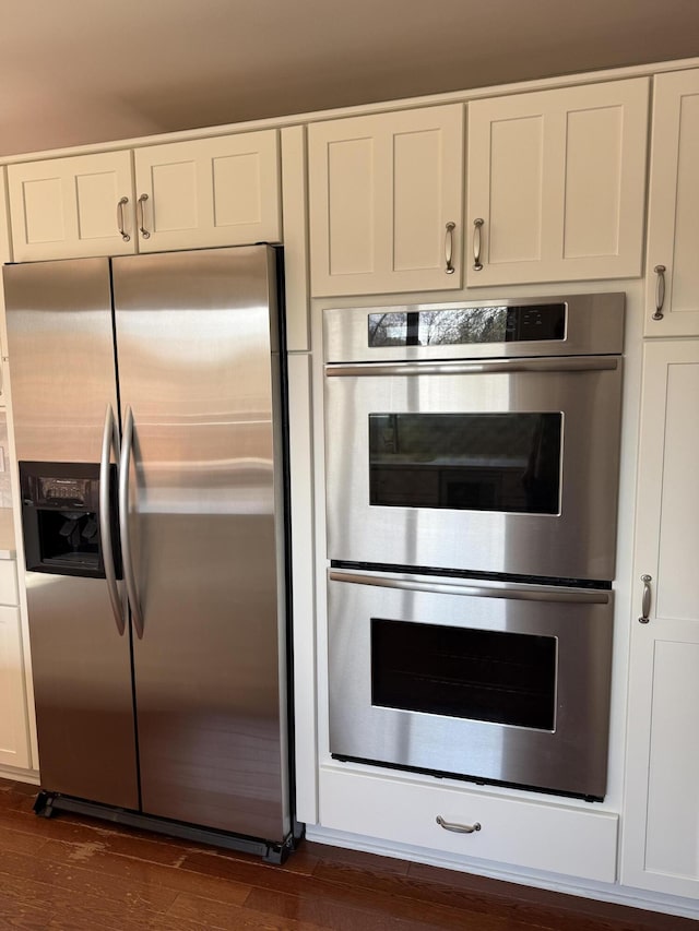 kitchen featuring dark wood-style flooring, stainless steel appliances, and white cabinetry