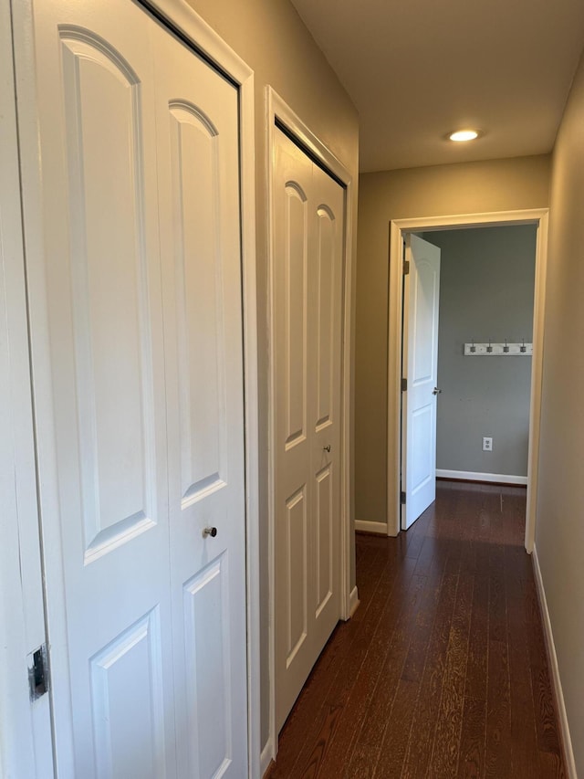 hallway featuring baseboards, recessed lighting, and dark wood finished floors