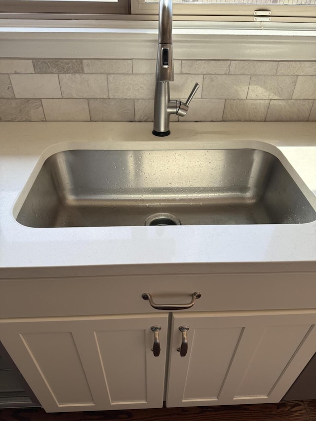 room details with light countertops, a sink, and tasteful backsplash
