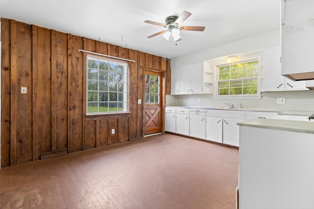 50505 Geddes Rd, Canton, MI 48188 - kitchen with hardwood / wood-style floors, ceiling fan, wooden walls, light countertops, and white cabinetry