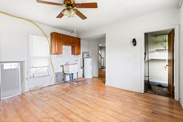 50505 Geddes Rd, Canton, MI 48188 - unfurnished living room featuring light wood-type flooring, a ceiling fan, stairs, and water heater