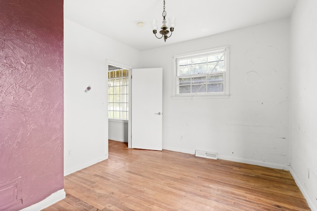 50505 Geddes Rd, Canton, MI 48188 - empty room with visible vents, light wood finished floors, plenty of natural light, and a notable chandelier
