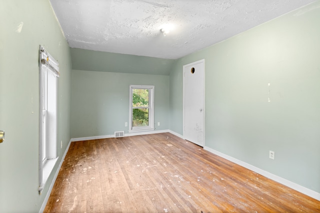 50505 Geddes Rd, Canton, MI 48188 - empty room with baseboards, visible vents, lofted ceiling, and hardwood / wood-style floors
