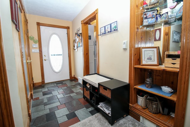 entryway with baseboards and stone finish flooring