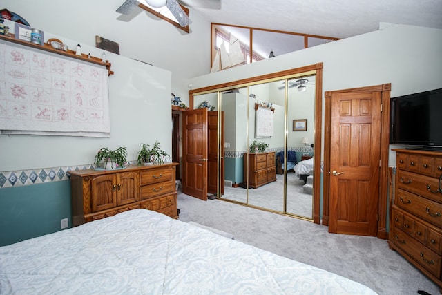 bedroom featuring high vaulted ceiling, ceiling fan, a closet, and light colored carpet