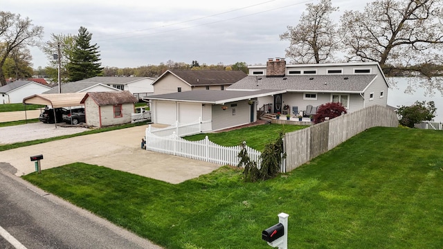 view of front of property with fence private yard, a front lawn, driveway, and a chimney