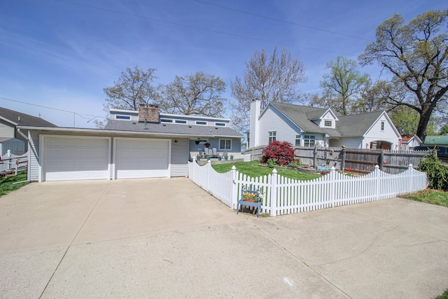 view of front of house with a detached garage, a fenced front yard, and a chimney