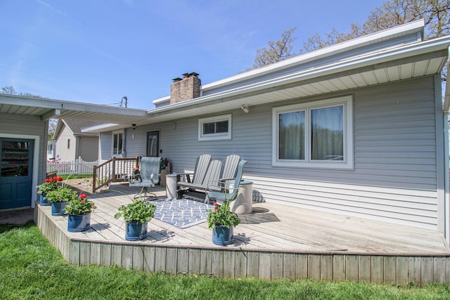 rear view of property with a wooden deck and a chimney