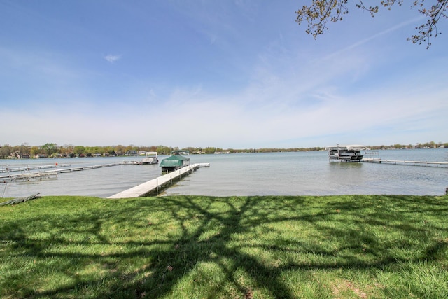 dock area with a lawn and a water view
