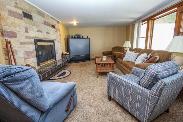carpeted living area featuring a stone fireplace