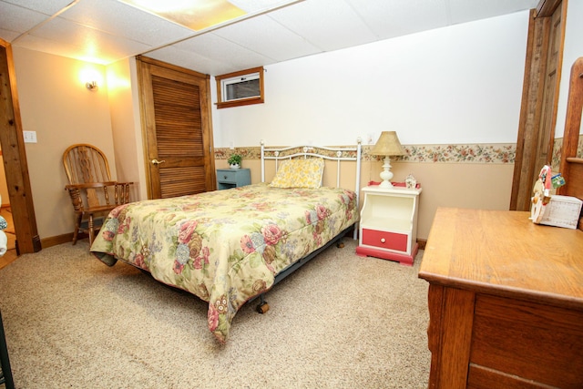 bedroom with carpet floors, baseboards, a closet, and a paneled ceiling