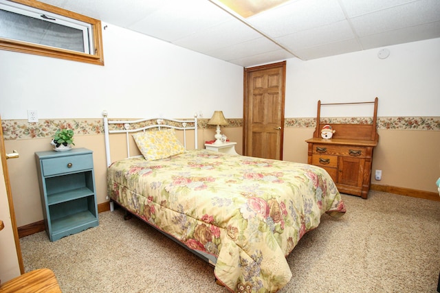 bedroom with light colored carpet, baseboards, and a drop ceiling