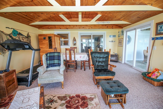 carpeted living area featuring baseboards, beamed ceiling, and wood ceiling