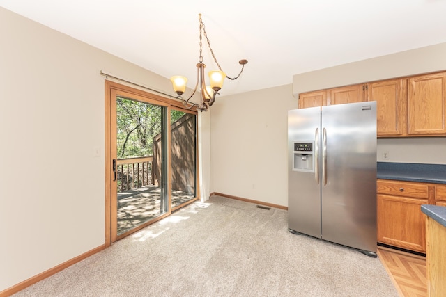 kitchen with visible vents, dark countertops, baseboards, stainless steel refrigerator with ice dispenser, and a notable chandelier