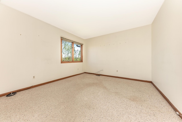 empty room with baseboards and carpet