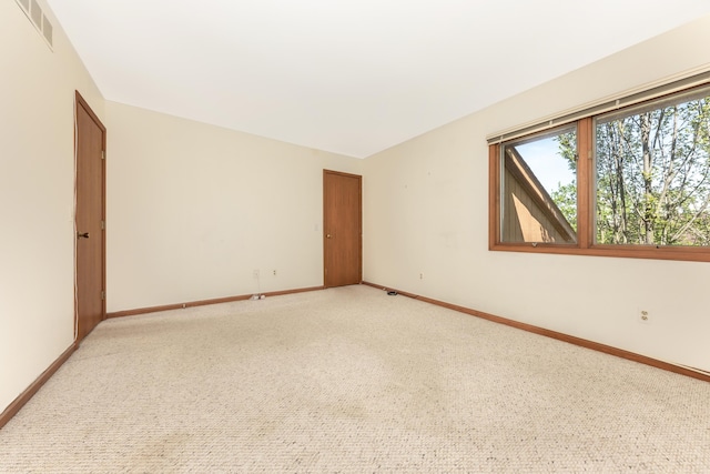 unfurnished room with visible vents, baseboards, and light carpet