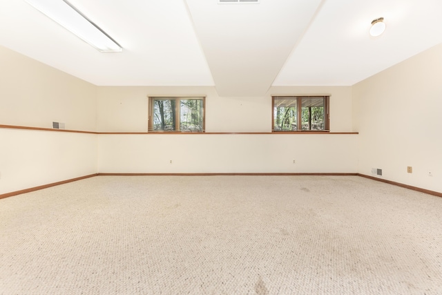 spare room featuring baseboards, carpet flooring, and visible vents
