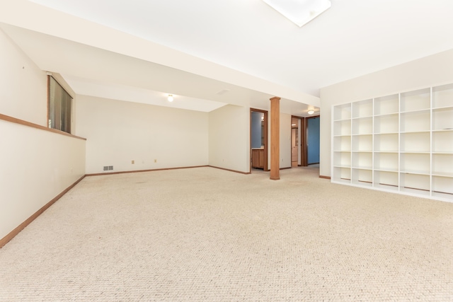 interior space with baseboards, visible vents, built in shelves, and light colored carpet