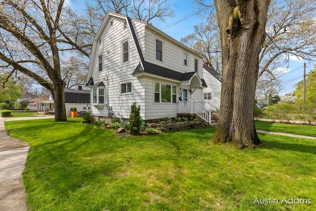 view of property exterior featuring a lawn, roof with shingles, and a gambrel roof