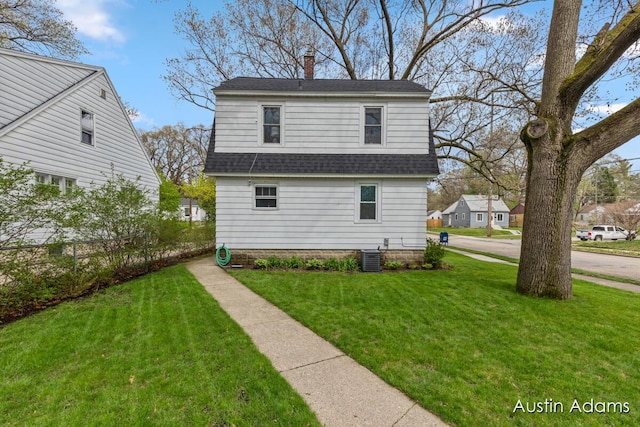 view of home's exterior featuring a lawn, a chimney, and roof with shingles