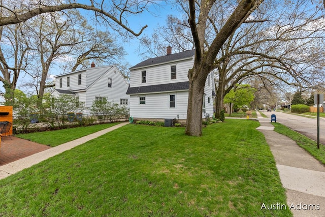 exterior space featuring a lawn, fence, a shingled roof, and a chimney