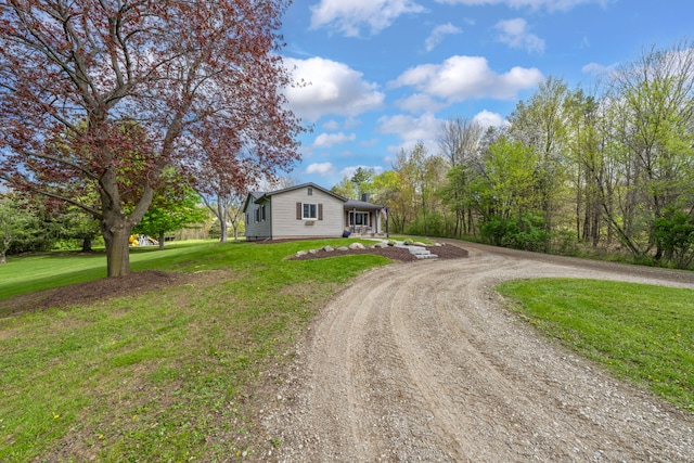 1205 Mckail Rd, Leonard, MI 48367 - view of front of house featuring driveway, a front yard, and a chimney