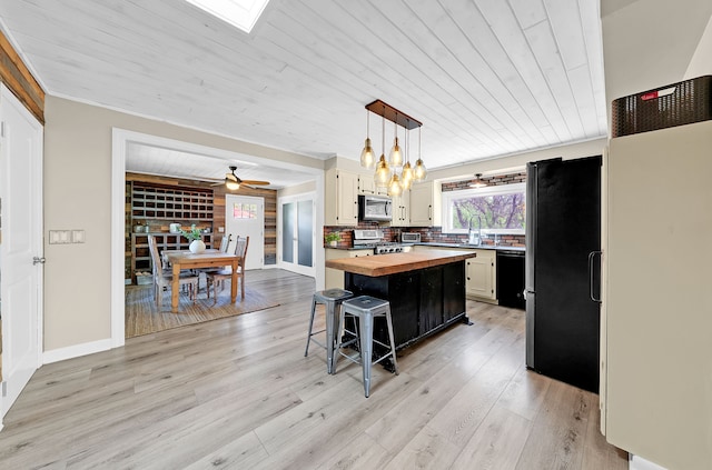 1205 Mckail Rd, Leonard, MI 48367 - kitchen with butcher block countertops, stainless steel appliances, a breakfast bar, wood ceiling, and light wood-style flooring